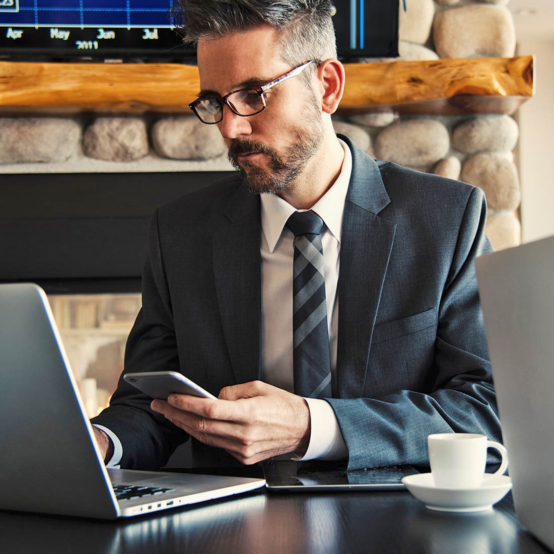 Man Working on Phone and Laptop